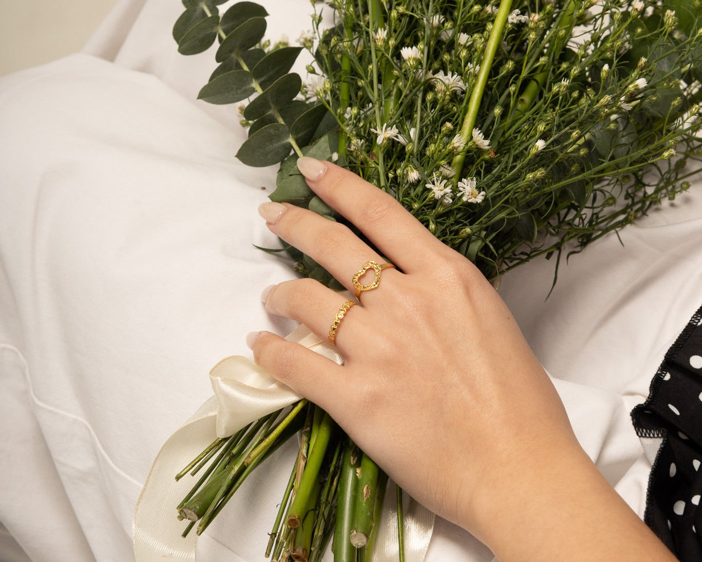 Hand holding a bouquet of flowers with a white background