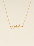Gold necklace with heart and line design on a beige background