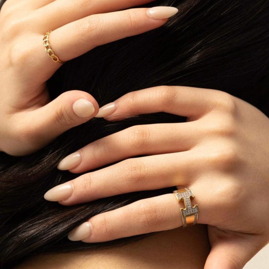 Close-up of hands with rings on a neutral background